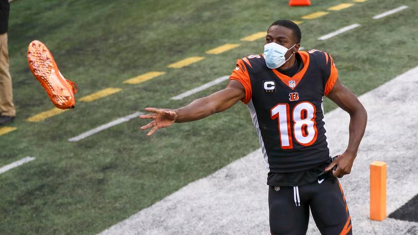 Cincinnati Bengals wide receiver A.J. Green (18) tosses a cleat to a fan after an NFL football game against the Baltimore Ravens, Sunday, Jan. 3, 2021, in Cincinnati. (AP Photo/Aaron Doster)