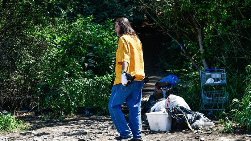 Doug Miller, who lives in the homeless camp beside the CSX railroad tracks behind the Hamilton Plaza shopping center, walks back to the camp after Hamilton Police and railroad police told residents they can no longer cross the tracks. NICK GRAHAM/STAFF