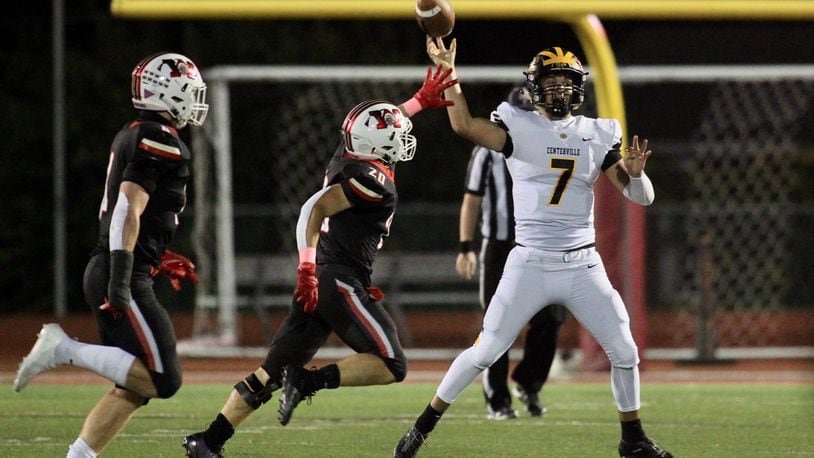Centerville's Chase Harrison throws a pass as he's pressured by Wayne's Kyle Johnson in a Division I, Region 2 playoff first-round game on Friday, Oct. 9, 2020, in Huber Heights. David Jablonski/Staff