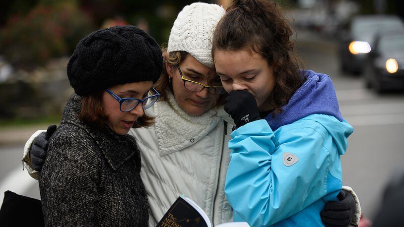 PITTSBURGH, PA - OCTOBER 27: Tammy Hepps, Kate Rothstein and her daughter, Simone Rothstein, 16, pray from a prayerbook a block away from the site of a mass shooting at the Tree of Life Synagogue in the Squirrel Hill neighborhood . (Photo by Jeff Swensen/Getty Images)