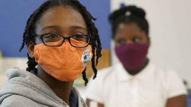 Students wear masks to help prevent the spread of COVID-19 as they listen during class, Tuesday, Aug. 10, 2021, during the first day of school at Washington Elementary School in Riviera Beach, Fla. (AP Photo/Wilfredo Lee)