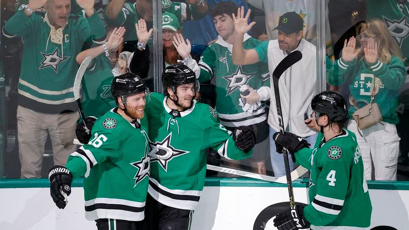 Dallas Stars center Wyatt Johnston, center, celebrates his first period goal with Joe Pavelski (16) and Miro Heiskanen (4) during Game 7 of an NHL hockey Stanley Cup first-round playoff series against the Vegas Golden Knights, Sunday, May 5, 2024, in Dallas. (AP Photo/Brandon Wade)