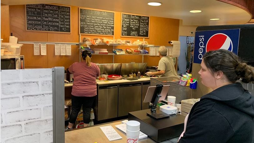 A customer waits for her order to be completed at the Main Street Deli which reopened Tuesday at the Marketplace Express/Marathon at 2 Remick Blvd. Owner Steve Swank said family-owned  business has been great so far at the new location. ED RICHTER/STAFF