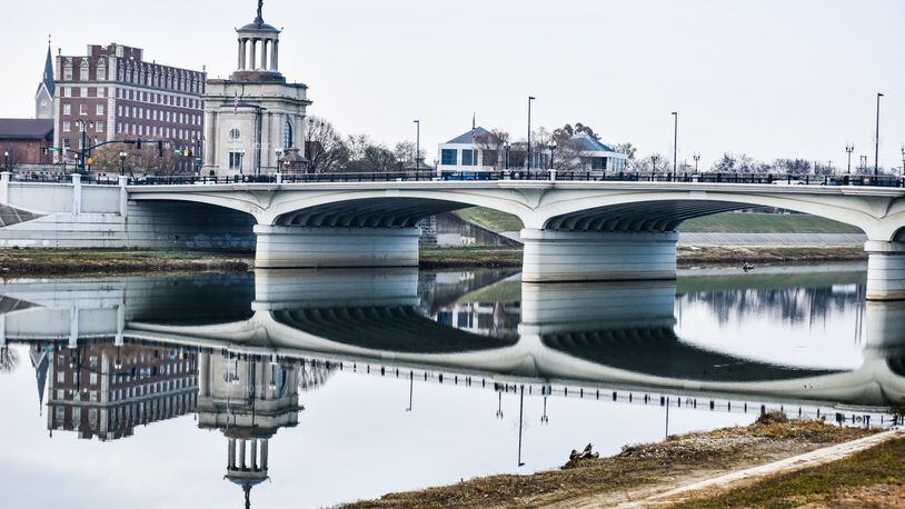 The High-Main Bridge and the Butler County Soldiers, Sailors and Pioneers Monument are reflected in the Great Miami River Tuesday, Nov. 19, 2019 in Hamilton. NICK GRAHAM/STAFF