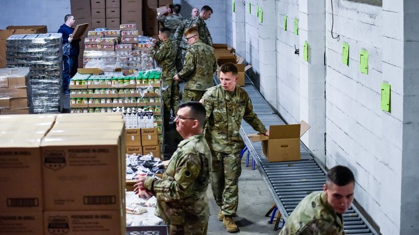 Members of the Ohio Army National Guard pack boxes of food on March 23 at Shared Harvest Food Bank in Fairfield. The Ohio Army National Guard was activated and helped food banks distribute to those in need, but federal funding is expected to run out. Ohio Gov. Mike DeWine has committed to having the National Guard continue assisting food banks. NICK GRAHAM/FILE