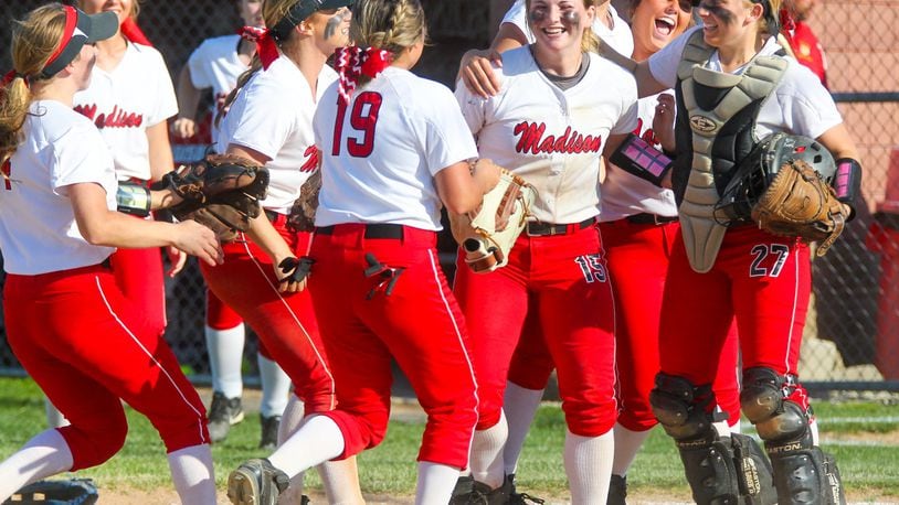 Madison pitcher Carly Metcalf (15) celebrates with teammates after the final out of their Division III sectional final victory over Carlisle on Monday at Fenwick. GREG LYNCH/STAFF