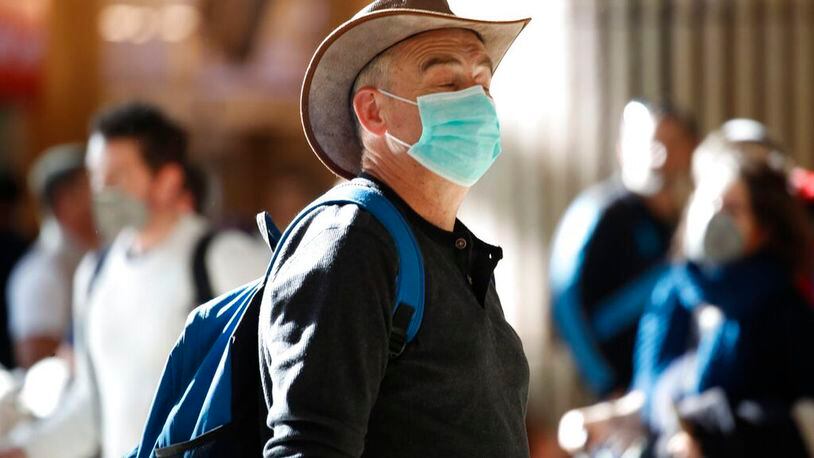 A man wearing a protective mask waits at the arrival hall in Ben Gurion Airport near Tel Aviv, Israel, Thursday, Feb. 27, 2020. Israel on Wednesday advised its citizens to reconsider all foreign travel amid the global spread of the new coronavirus that was first reported in China.