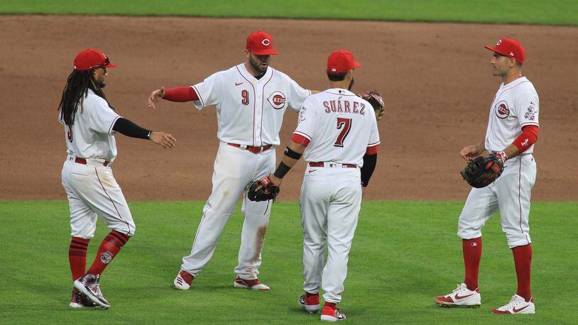 The Reds celebrate after beating the Tigers on Opening Day on Friday, July 24, 2020, at Great American Ball Park in Cincinnati. David Jablonski/Staff