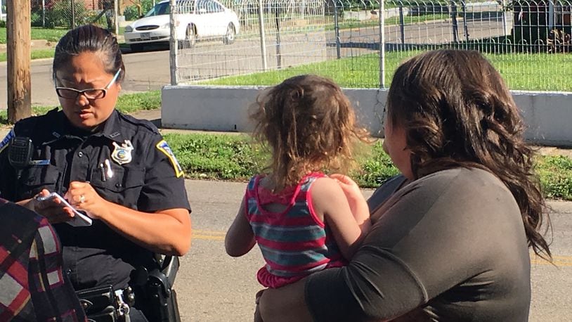 Middletown police Officer Becki French interviews Shea Redmon, 25, of Hamilton, on Tuesday after Redmon said she found a 2-year-old girl standing on Baltimore Street. The girl’s babysitter told police the girl must have walked out of the house. RICK McCRABB/STAFF