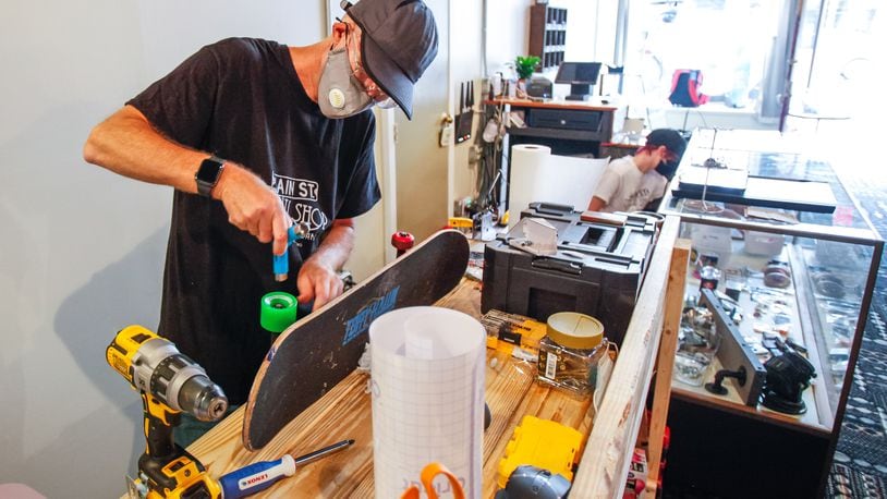 John Simmons, owner of Main Street Throw Shop, works on a skateboard on opening day at the business, Aug. 14. The Hamilton shop offers a wide variety of disc golf discs and bags, skateboards and accessories and has an area to test discs before you buy. NICK GRAHAM / STAFF