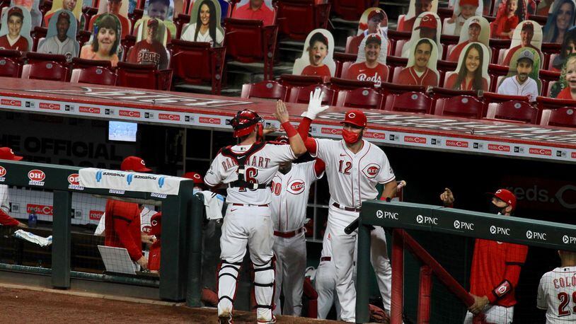 Reds catcher Tucker Barnhart, center, slaps hands with Curt Casali after the final out of the eighth inning on Monday, Aug. 3, 2020, during a game against the Indians at Great American Ball Park. David Jablonski/Staff