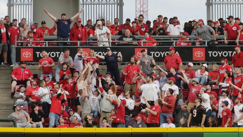 Fans try to catch a home run hit by Andres Gimenez, of the Guadians, against the Reds in the ninth inning on Opening Day on Tuesday, April 12, 2022, at Great American Ball Park in Cincinnati. David Jablonski/Staff