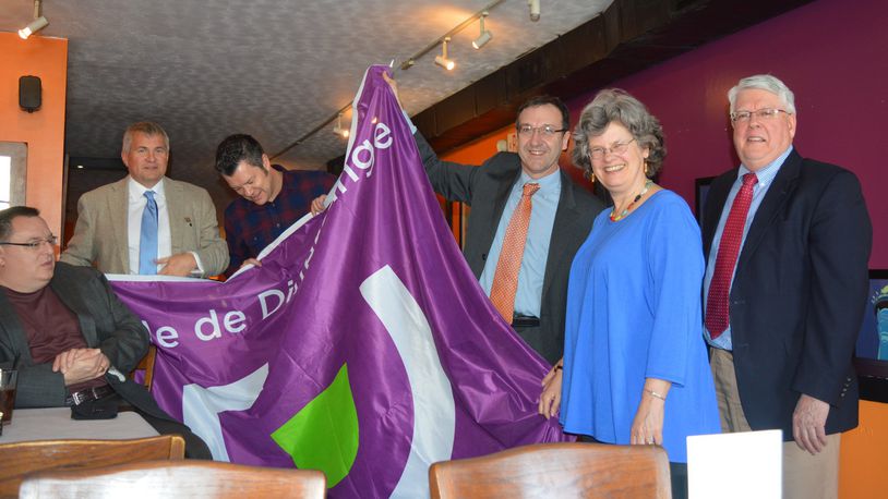 A presentation of a flag of Differdange to the city of Oxford. Pictured, from left, are: Oxford Council member Kevin McKeehan (seated); Tom Ulveling, a member of the Differdange City Council; Henri Kreck , secretary of Differdange, the equivalent of a city manager here; Thierry Leterre, the dean of the Miami University Dolibois European Center in Luxembourg; Oxford Mayor Kate Rousmaniere and City Manager Doug Elliott. CONTRIBUTED/BOB RATTERMAN