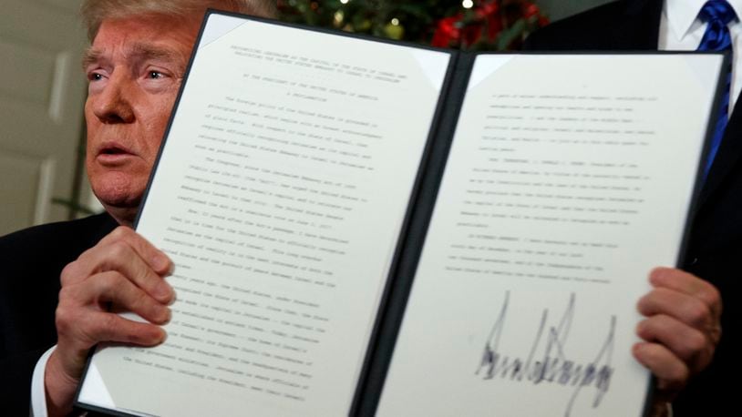 President Donald Trump holds up a proclamation to officially recognize Jerusalem as the capital of Israel, in the Diplomatic Reception Room of the White House, Wednesday, Dec. 6, 2017, in Washington. (AP Photo/Evan Vucci)