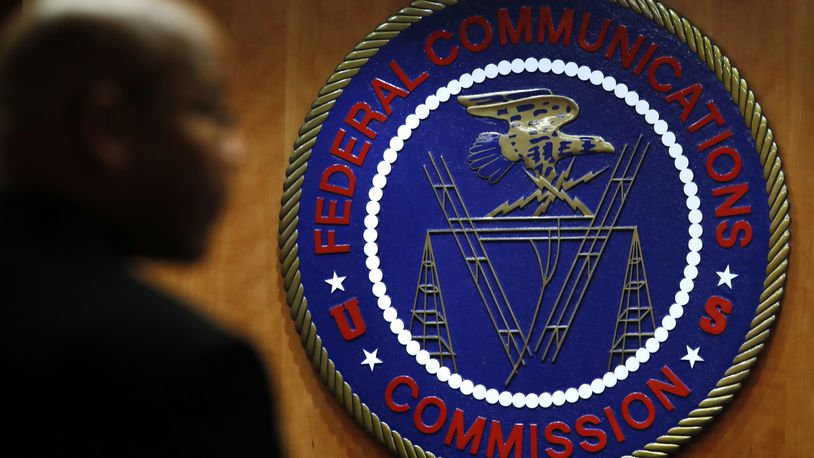 FILE- This Dec. 14, 2017, file photo, shows the seal of the Federal Communications Commission (FCC) before a meeting in Washington. Congressional leaders and a media accountability organization are urging the Federal Communications Commission to investigate its "history of racism" and examine how policy decisions have disparately harmed Black people and other communities of color, according to a letter sent Tuesday, June 29, 2021, to the acting FCC chair. (AP Photo/Jacquelyn Martin, File)