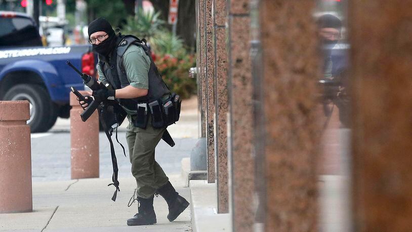 An armed shooter stands near the Earle Cabell Federal Building Monday, June 17, 2019, in downtown Dallas. The shooter was hit and injured in an exchange of gunfire with federal officers outside the courthouse.  (Tom Fox/The Dallas Morning News)