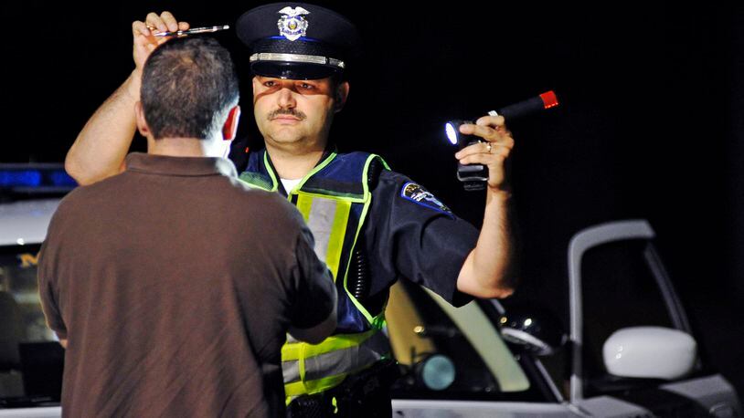 Monroe police officer Doug Leist gives a field sobriety test to a man stopped during an OVI checkpoint Early Saturday morning, June 11, 2011 along OH-4 in Monroe, Ohio.  Monroe police, along with Middletown police and the Ohio State Highway Patrol, participated in the checkpoint.  Staff photo by Nick Graham