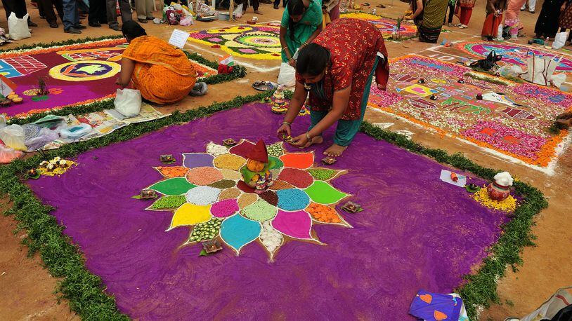 Indian women participate in a Rangoli competition (hindu ritual design) in Hyderabad, on January 11, 2012. Rangoli is a traditional decorative folk art from India. These are decorative designs made on floors of living rooms and courtyards  are meant as sacred welcoming areas for the Hindu deities  during Sankranthi festival is also known as the harvest festival and is celebrated on 14th January through the country and marks the transition from winter to spring. AFP PHOTO / Noah SEELAM (Photo credit should read NOAH SEELAM/AFP/Getty Images)