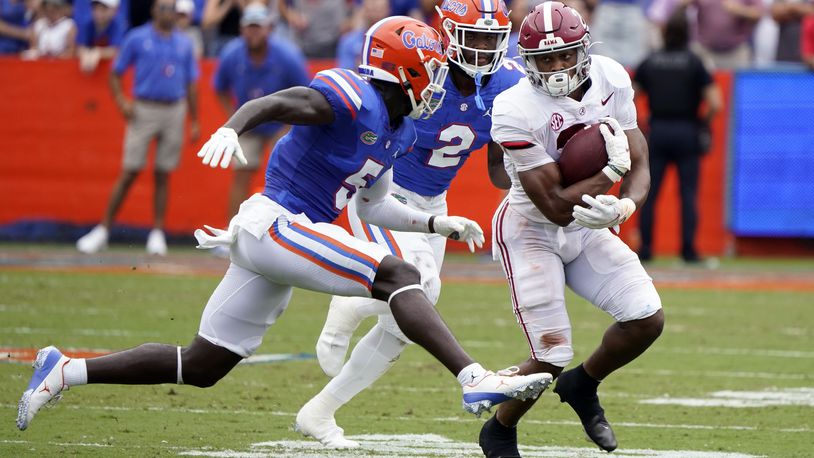 Alabama running back Jase McClellan, right, gains yardage as he tries to get past Florida cornerback Kaiir Elam (5) and linebacker Amari Burney (2) during the first half of an NCAA college football game, Saturday, Sept. 18, 2021, in Gainesville, Fla. (AP Photo/John Raoux)