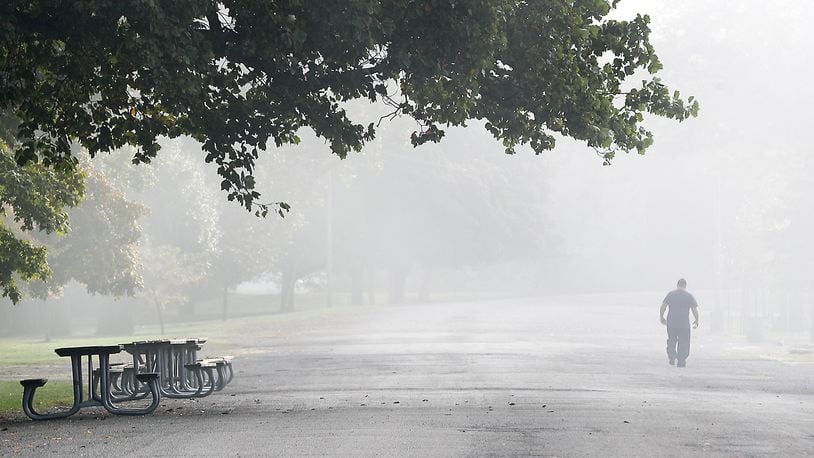 A man is shrouded in the fog that blanketed the area Oct. 5 as he walks at Snyder Park in Springfield. BILL LACKEY/STAFF