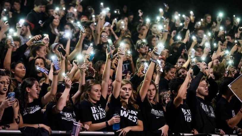 Lakota East football fans light up the night during a 35-0 win at Lakota West on Sept. 29, 2017, in West Chester Township. NICK GRAHAM/STAFF
