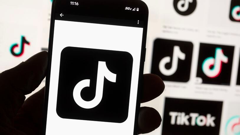 FILE - The TikTok logo is displayed on a mobile phone in front of a computer screen, Oct. 14, 2022, in Boston. On Tuesday, May 7, 2024, TikTok and its Chinese parent company ByteDance filed suit against the U.S. federal government to challenge a law that would force the sale of ByteDance's stake or face a ban, saying that the law is unconstitutional. (AP Photo/Michael Dwyer, File)