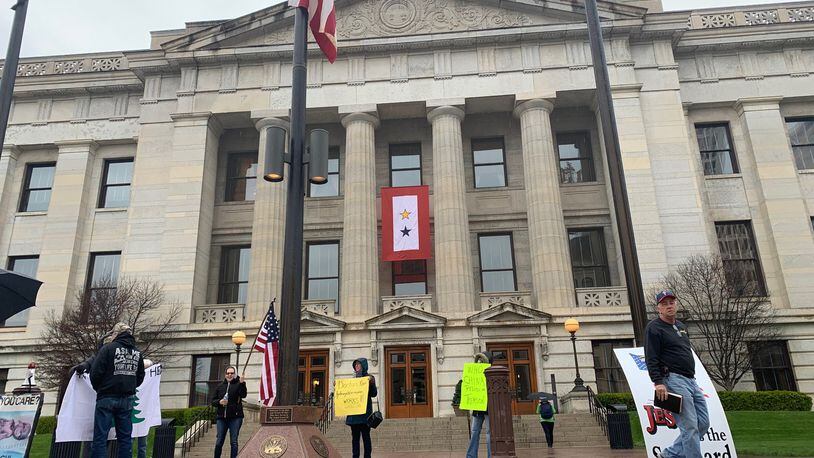 A small group of protesters assembled at the Ohio Statehouse just before the governor’s daily briefing on Friday. Laura Bischoff/Staff