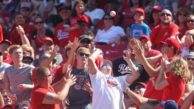 Fans try to catch a foul ball during a game between the Reds and the A's on Saturday, June 11, 2016, at Great American Ball Park in Cincinnati. David Jablonski/Staff