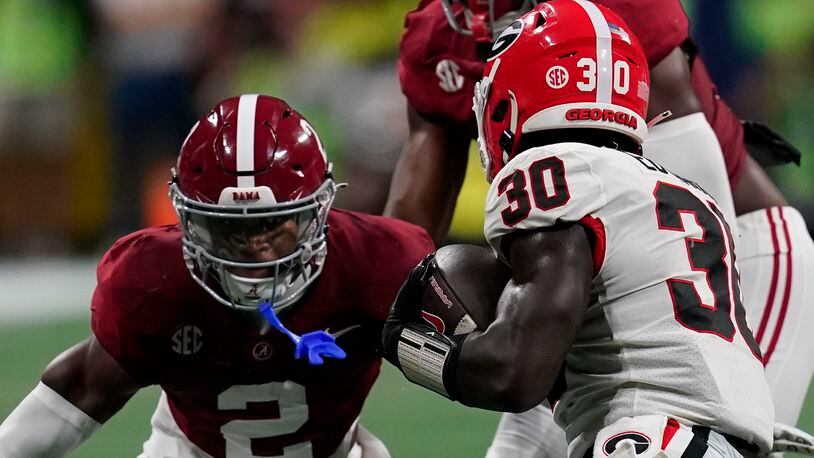 Georgia running back Daijun Edwards (30) runs the ball against Alabama defensive back Caleb Downs (2) during the first half of the Southeastern Conference championship NCAA college football game in Atlanta, Saturday, Dec. 2, 2023. (AP Photo/Mike Stewart)