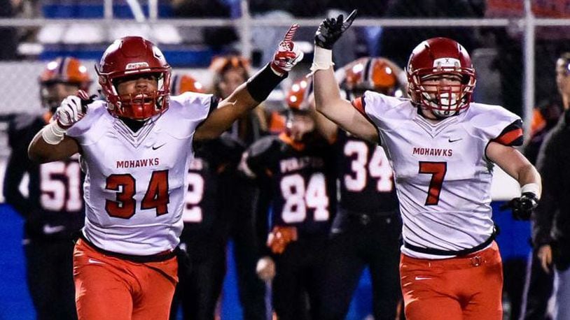 Madison’s Evan Crim (34) and Mason Whiteman (7) celebrate a good moment in a Division V state semifinal on Nov. 24, 2017, at Herrnstein Field in Chillicothe. NICK GRAHAM/STAFF