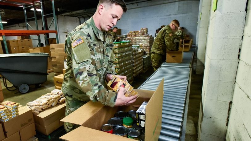 Sgt. Kennith Moss, from Hamilton, and other members of the Ohio Army National Guard pack boxes of food at Shared Harvest Food Bank Monday, March 23, 2020 in Fairfield. The Ohio Army National Guard was activated and helped pack food to be distributed to those in need throughout the area. NICK GRAHAM / STAFF