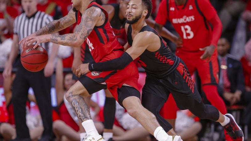 CINCINNATI, OH - MARCH 10: Jarron Cumberland #34 of the Cincinnati Bearcats dribbles the ball in the back court as Galen Robinson Jr. #25 of the Houston Cougars defends from behind at Fifth Third Arena on March 10, 2019 in Cincinnati, Ohio. The Bearcats beat the Cougars in Sunday’s AAC championship game in Memphis. (Photo by Michael Hickey/Getty Images)