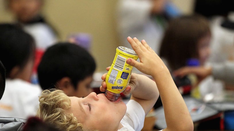 File photo: A student drinks a bottle of Nesquik chocolate milk during lunch.