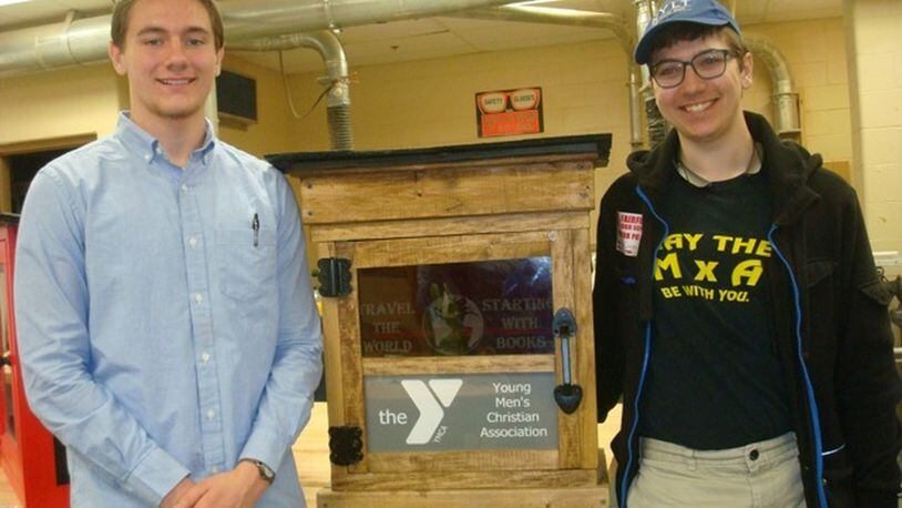 Butler Tech students T.J. Icenogle and Isaac Gruver with the Fairfield YMCA Little Free Library donation. CONTRIBUTED