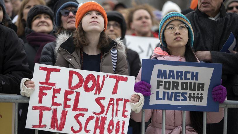Madeline Pollock, left, 14, and Lena Brockway, 15, hold signs as thousands gather in Union Park for the March for our Lives protest in Chicago on Saturday March 24, 2018. (Erin Hooley/Chicago Tribune/TNS)