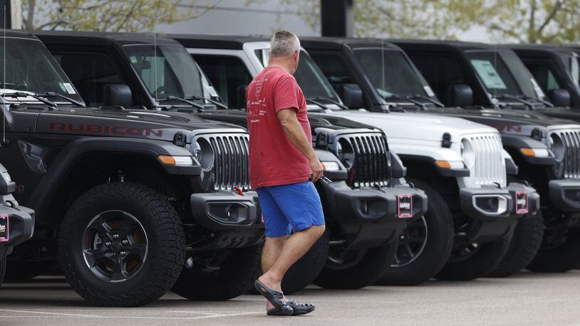 In this April 26 photo, a prospective buyer looks over a row of unsold 2020 Wranglers at a Jeep dealership. To spur car sales amid the coronavirus pandemic, nearly every automaker has introduced 0% financing. Getting a 0% car loan can be a smart way to finance a new car. (AP Photo/David Zalubowski)