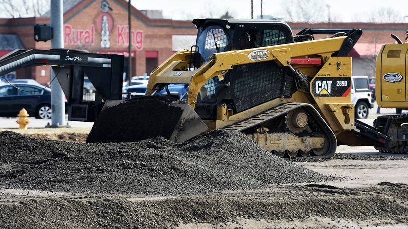 A worker with Webb’s Excavating was operating a compactor Tuesday on the site of a future Chipotle Mexican Grill on Main Street in Hamilton. MIKE RUTLEDGE/STAFF
