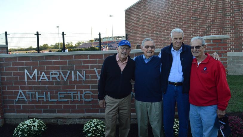 Colleagues in coaching, teaching, school administration and friendship (from left) Bill Bowers, Marvin Wilhlem, Dave Butcher and Joe Pyfrin gathered for a photo at the new sign designating the Marvin Wilhelm Athletic Complex at Talawanda High School. CONTRIBUTED/BOB RATTERMAN