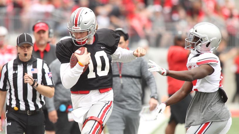 Ohio State’s Joe Burrow, left, is pushed out of bounds during the spring game on Saturday, April 14, 2018, at Ohio Stadium in Columbus. David Jablonski/Staff