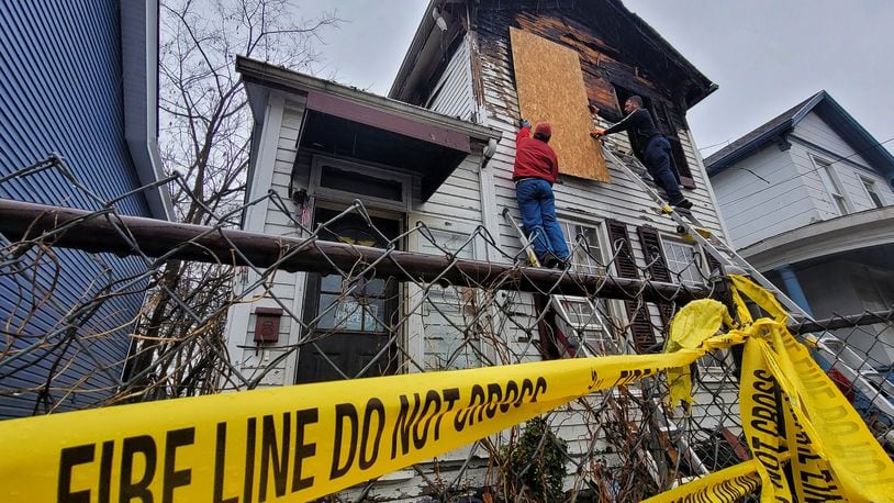 A crew works to board up a house in the 400 block of East Avenue after a fire in the early morning hours Tuesday, Dec. 28, 2021 in Hamilton. NICK GRAHAM / STAFF