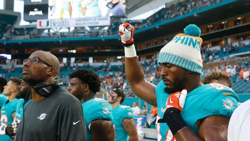 Miami Dolphins defensive end Robert Quinn raises his right fist during the singing of the national anthem before Thursday night's preseason game.
