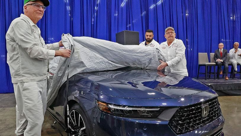 Honda associates Rick VanGundy, left, and Mike Rausch, right, unveil the new 2023 Honda Accord as Gov. Mike DeWine looks on in the background Thursday, Jan. 5, 2023. Both VanGunday and Rausch have worked at the Honda Marysville Plant since it opened. BILL LACKEY/STAFF