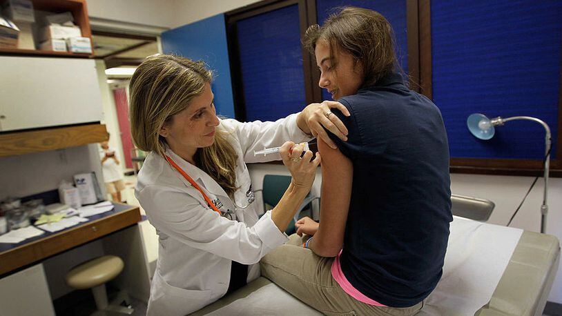 Pediatrician Judith L. Schaechter, M.D. (L) gives an HPV vaccination to a 13-year-old girl in her office. A new 2019 study on the HPV vaccine shows its benefits “exceed expectations” and may lead to the elimination of cervical cancer.