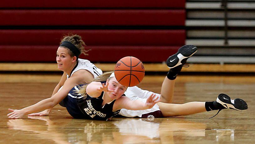 Edgewood guard Cierra Lipps passes to a teammate while underneath Lebanon guard Ashley West during their game at Lebanon on Monday night. CONTRIBUTED PHOTO BY E.L. HUBBARD