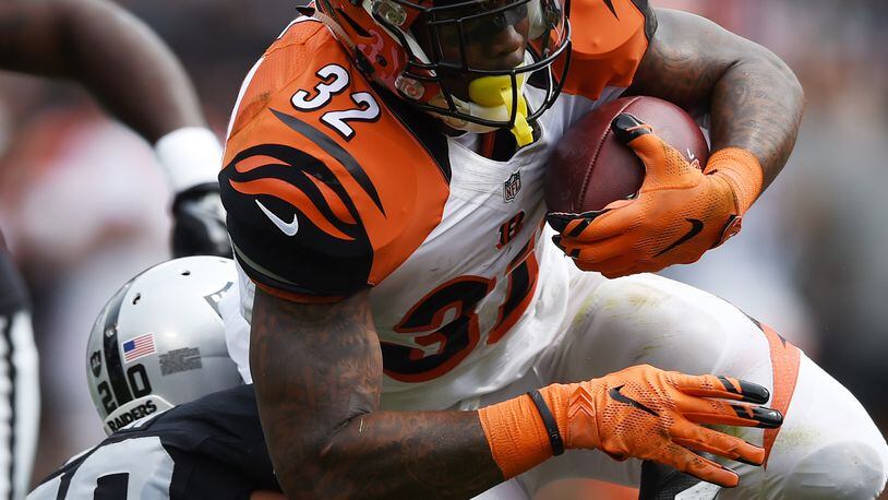 OAKLAND, CA - SEPTEMBER 13: Jeremy Hill #32 of the Cincinnati Bengals is hit by Nate Allen #20 of the Oakland Raiders during the first half of their NFL game at O.co Coliseum on September 13, 2015 in Oakland, California. (Photo by Thearon W. Henderson/Getty Images)