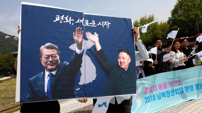 South Koreans hold up placards of South Korean President Moon Jae-In and North Korean leader Kim Jong-Un during a rally welcoming the planned Inter Korean Summit in front of Presidential Blue House on April 26, 2018 in Seoul, South Korea.