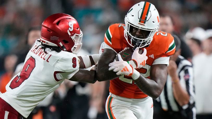 Miami (Ohio) defensive back Jeremiah Caldwell (9) pushes Miami running back Mark Fletcher Jr. out of bounds during the first half of an NCAA college football game, Friday, Sept. 1, 2023, in Miami Gardens, Fla. (AP Photo/Wilfredo Lee)