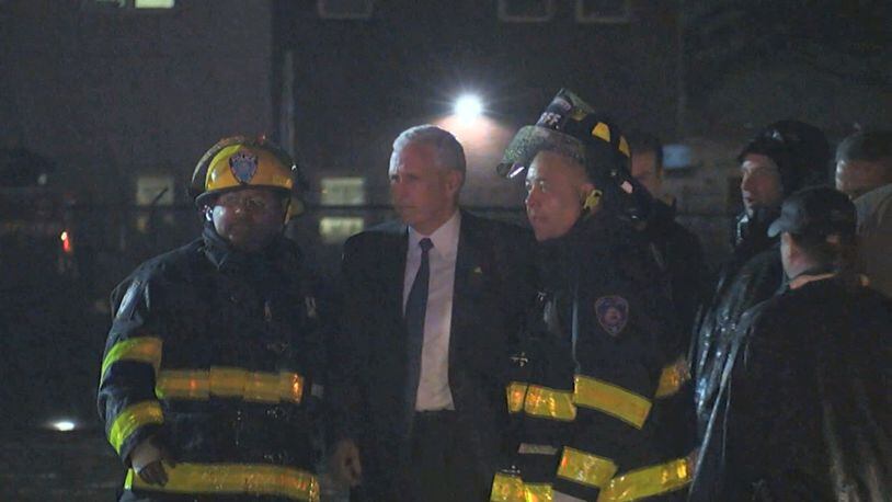 Republican presidential candidate Indiana Gov. Mike Pence talks with firefighters at New York's LaGuardia Airport after his campaign plane slide off the runway while landing on Thursday, Oct. 27, 2016. (TV Network Pool via AP)