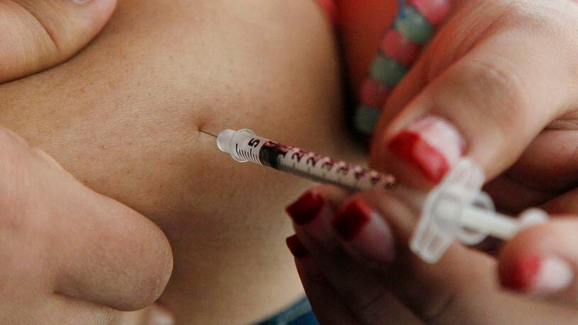 FILE - In this April 29, 2012 file photo, a woman diagnosed with diabetes gives herself an injection of insulin at her home in the Los Angeles suburb of Commerce, Calif. (AP Photo/Reed Saxon, File)