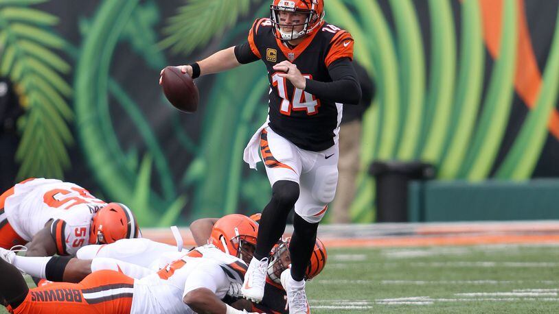 CINCINNATI, OH - NOVEMBER 25: Andy Dalton #14 of the Cincinnati Bengals slips out of an attempted tackle by Myles Garrett #95 of the Cleveland Browns during the second quarter at Paul Brown Stadium on November 25, 2018 in Cincinnati, Ohio. (Photo by John Grieshop/Getty Images)